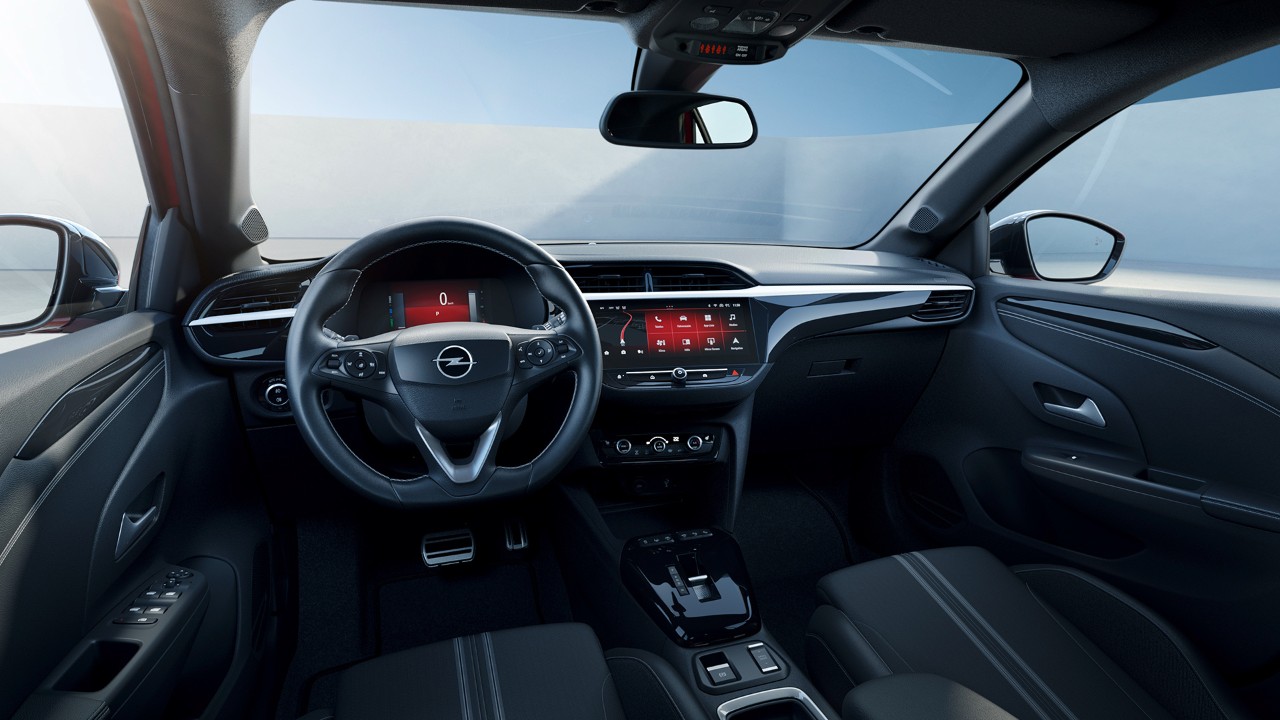 Opel Corsa Electric black interior side view from passenger seat with woman in background in yellow shirt